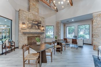 Community lounge with stone fireplace and dining tables